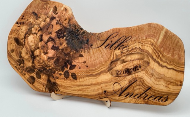 Engraved wooden sign with names, wedding rings and the date
