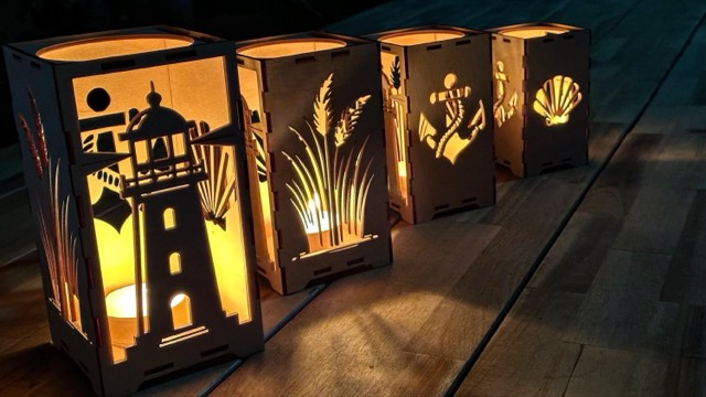 Wooden lanterns with lighthouse and anchor motifs, tealights burning inside