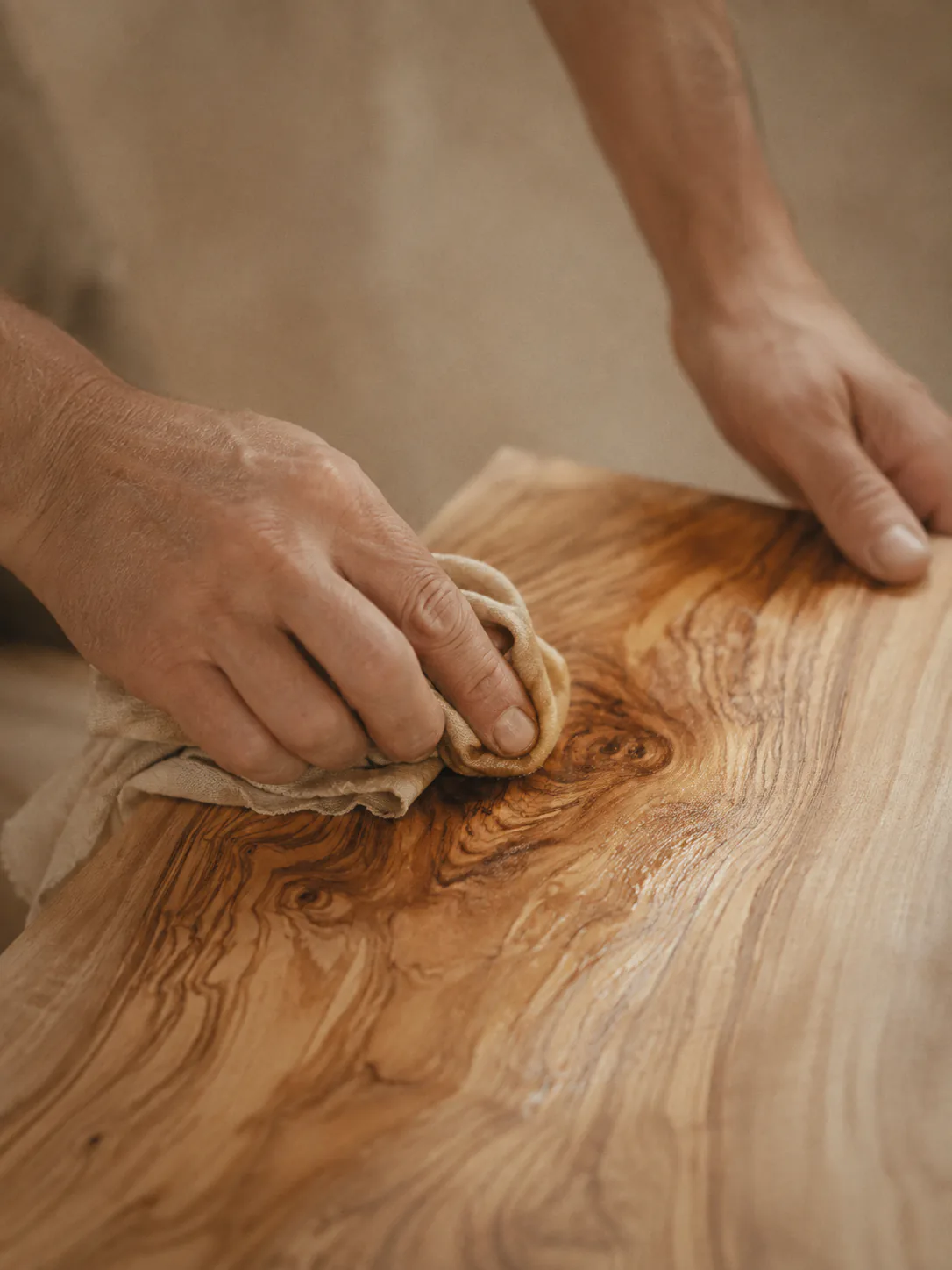 Hands oiling an olive wood board